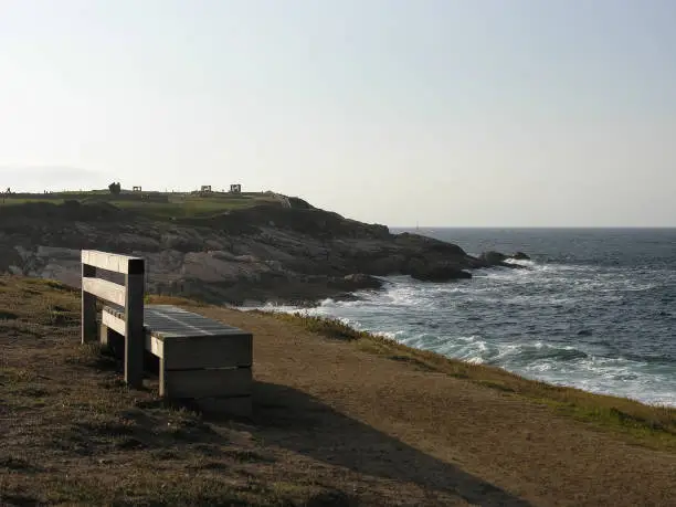 Lonely bench on the coast overlooking the sea.