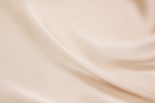 La textura de la tela del satén de color beige para el fondo photo