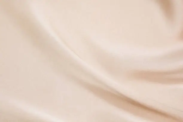 Photo of The texture of the satin fabric of beige color for the background