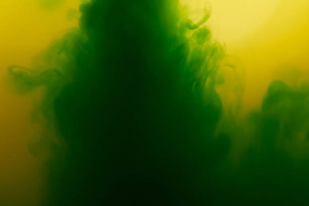istock Green paint flow in yellow water 1075249738