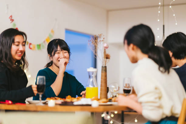 grupo de amigas disfrutando de la fiesta de navidad en casa - asian meal fotografías e imágenes de stock