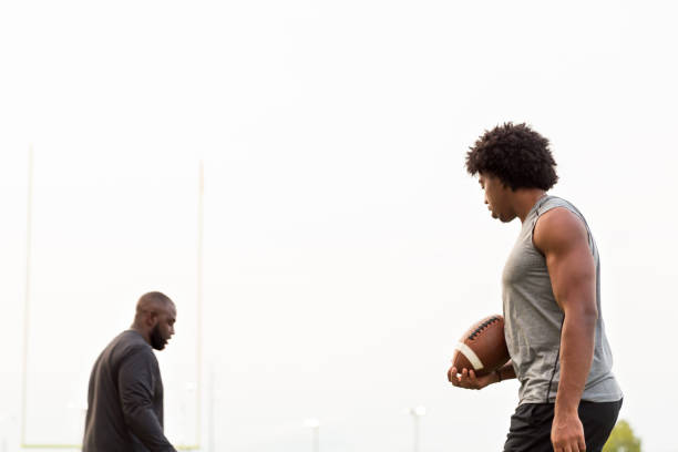 istock American Football coach training a young athlete. 1075277302
