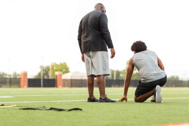 istock American Football coach training a young athlete. 1075278332