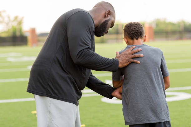 istock American Football coach training a young athlete. 1075278346