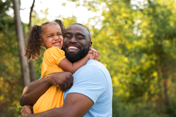 Little girl hugging her dad. Father and his daughter laughing and playing outside. single father stock pictures, royalty-free photos & images