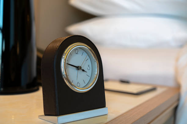 istock alarm clock on side table in bedroom 1075278624