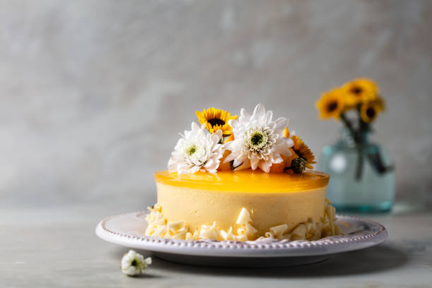istock Glazed Mango cheesecake with flowers and fresh mango pieces on grey background , horizontal composition 1075285786