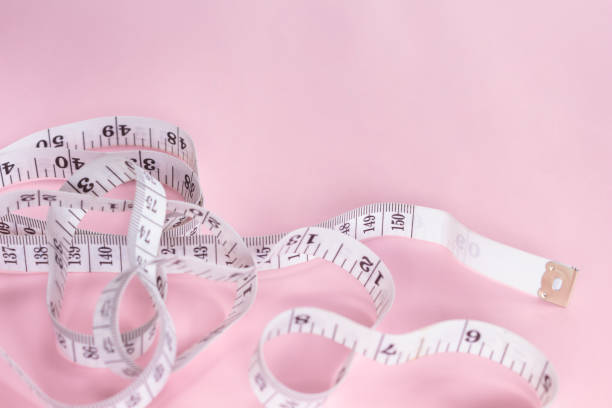 istock measure tape tool of sewing work on pink background. 1075292874