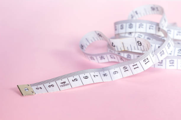 istock measure tape tool of sewing work on pink background. 1075292940