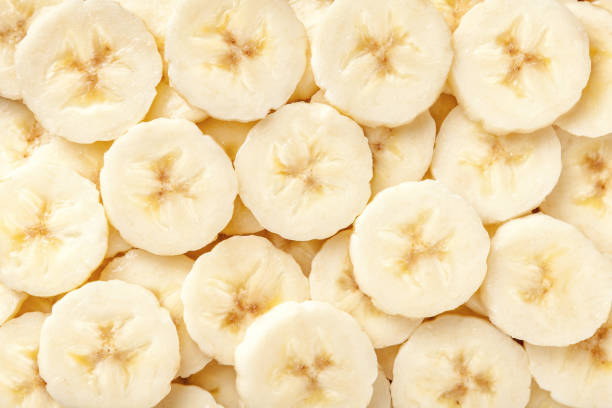 Background of ripe sliced banana slices, closeup. Background of ripe sliced banana slices, closeup. Food backdrop from fruit. banana stock pictures, royalty-free photos & images