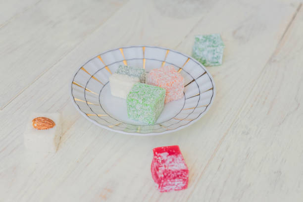 istock Traditional turkish delight on a plate on white wooden background. Assorted Oriental sweets. 1075309606
