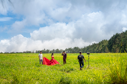 Da Lat Town, Lam Dong province, Vietnam - November 9, 2018: A group of photographers is doing a wedding photography on the meadow in Dalat town, Vietnam