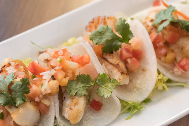 istock Jicama Fish Tacos with Salsa and Cilantro on White Platter 1075335188
