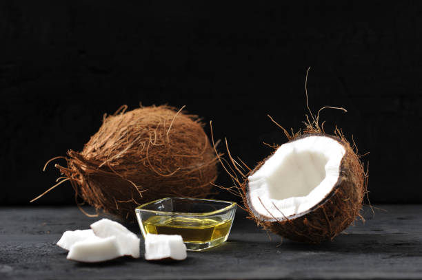 whole coconut, split coconut and coconut oil whole coconut, split coconut and coconut oil on dark wooden background COCONUT OLI stock pictures, royalty-free photos & images