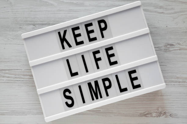 istock 'Keep life simple' words on modern board over white wooden table, overhead view. Flat lay, from above. 1075369982