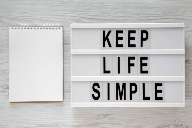 istock 'Keep life simple' words on modern board, blank notepad over white wooden surface, overhead view. Flat lay, from above. Space for text. 1075369990
