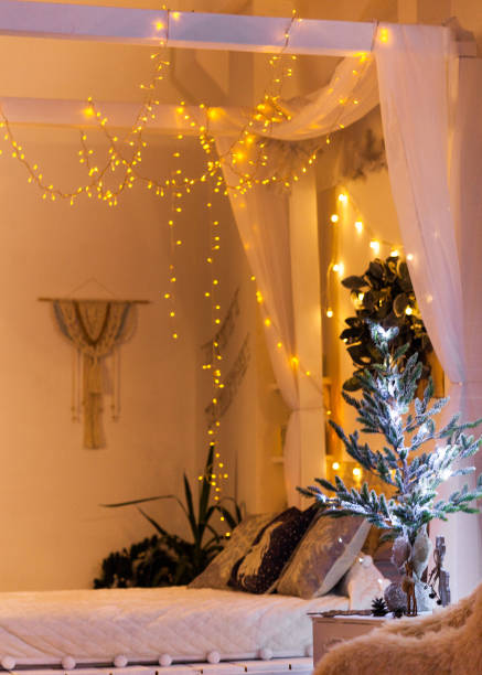 istock White cozy bed and Christmas lights 1075370632