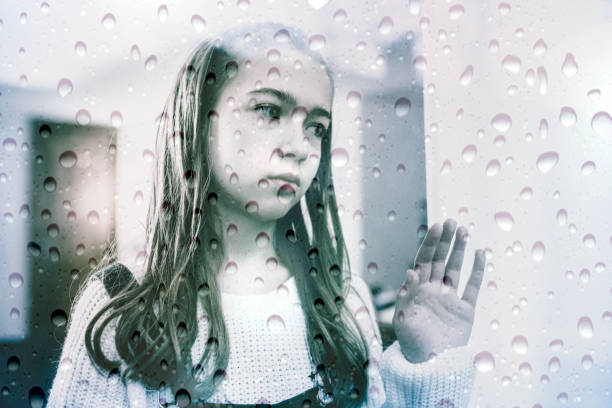 istock Lonely Child Near the Window 1075375664