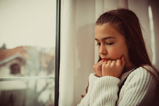 istock Lonely Child Near the Window 1075376198
