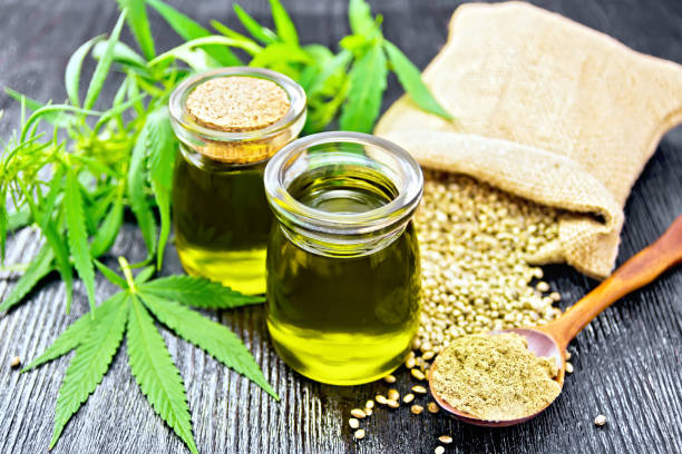 istock Oil hemp in two jars and flour in spoon on board 1075376228