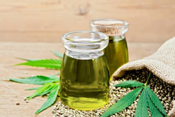 istock Oil hemp in two jars with sheet on wooden board 1075376238