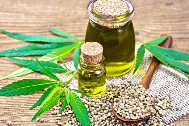 istock Oil hemp in two jars on wooden board 1075376242