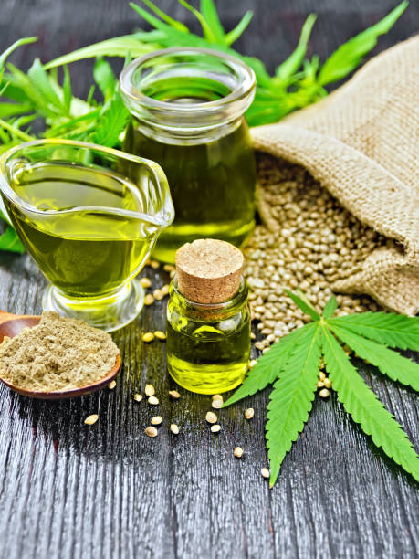 istock Oil hemp in two jars and sauceboat on black board 1075376254