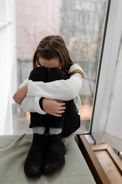 istock Lonely Child Near the Window 1075378598