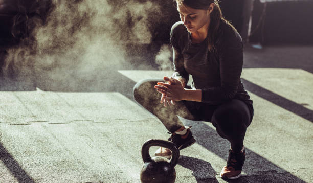 giovane donna in forma esercizio con kettleball - cross training foto e immagini stock
