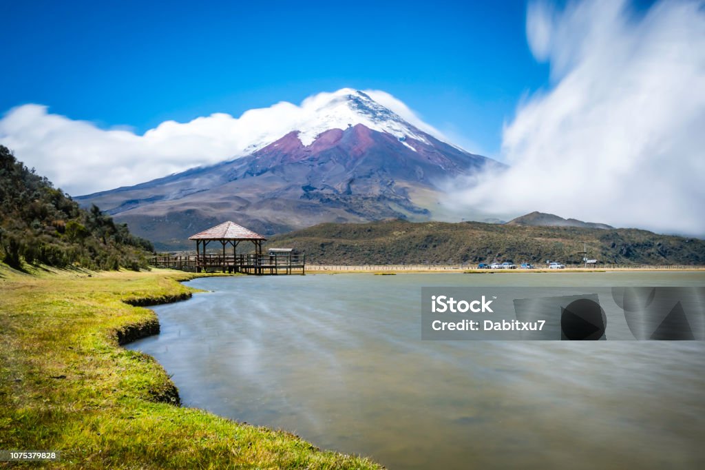 Cotopaxi volcano and gazebo Cotopaxi volcano and wooden gazebo at the bottom of the mountain in a sunny and windy day. exposure of 10 secs. Ecuador Stock Photo