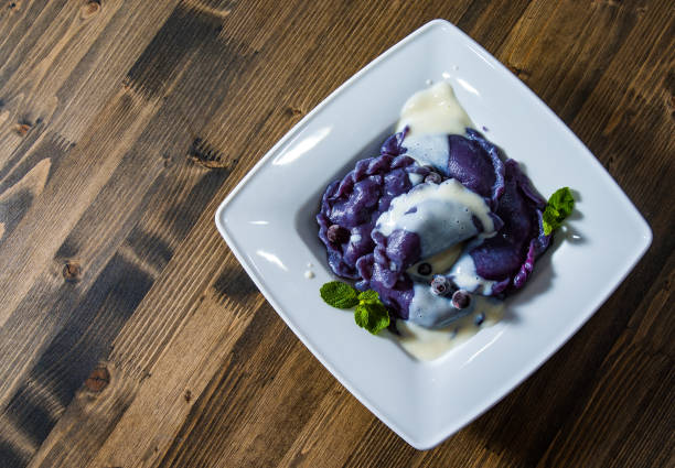 istock Dumplings with blueberries and cream. on a wooden background 1075385106