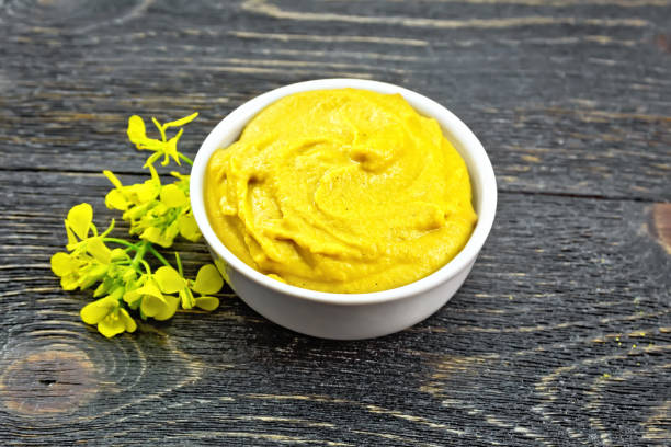 istock Sauce mustard in bowl with flower on black board 1075387302