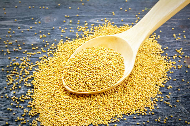 istock Mustard seeds in wooden spoon on black board 1075390040