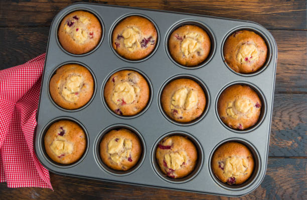 istock Cranberry muffins with ricotta in baking form on wooden table, top view 1075397552
