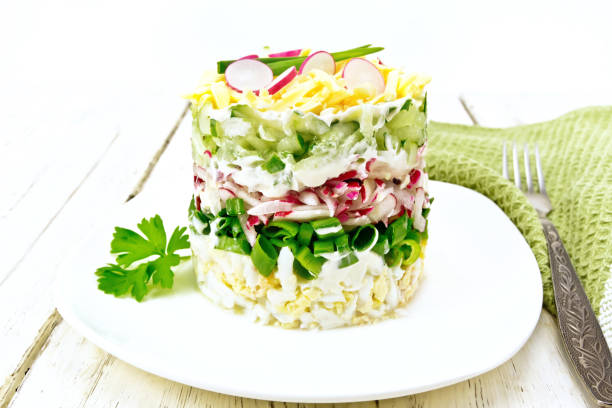 istock Salad layered with radish and cucumber in plate on board 1075401298