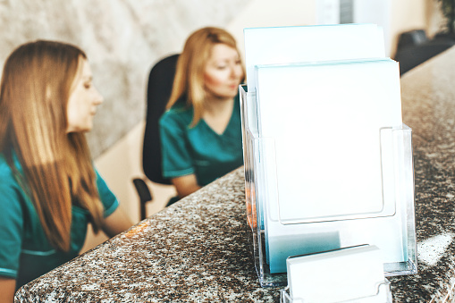 Blank business card and advertisement in a medical clinic. Blurred people background.