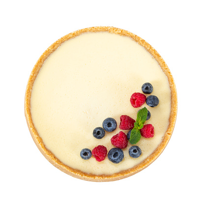 Whole classic cheesecake with raspberries, blueberries and mint isolated on white background. Top view.