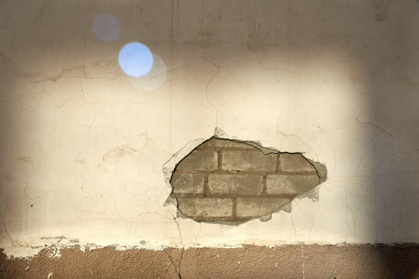 istock The wall caved in, the plaster and the bricks are visible. 1075414908