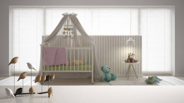 istock White table top or shelf with minimalistic bird ornament, birdie knick - knack over blurred nursery with canopy cradle, carpet and bedside table, modern interior design 1075417170