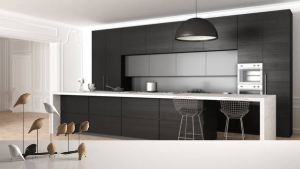 istock White table top or shelf with minimalistic bird ornament, birdie knick - knack over modern kitchen in classic apartment, cabinets, island and stools, pendant lamp, modern interior design 1075417242