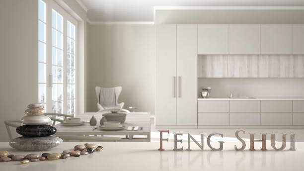 wooden vintage table shelf with stone balance and 3d letters making the word feng shui over classic beige kitchen with dining table laid for two, zen concept interior design - fengshui imagens e fotografias de stock