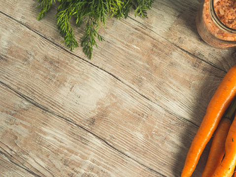 Raw carrots on rustic wooden background. Cooking vegetables