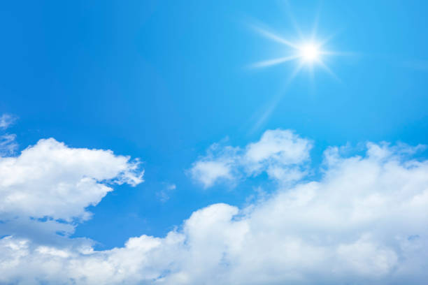 istock bright blue sky with sun and clouds background 1075425688