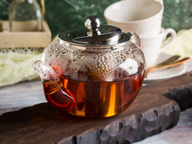 istock Hot tea in glass tea pot over green background 1075425970