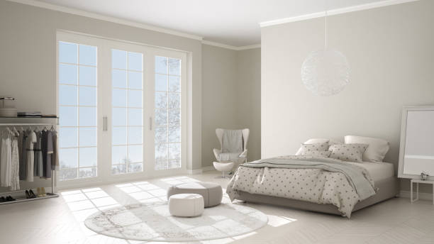 istock Comfortable modern white and beige bedroom with wooden parquet floor, panoramic window on winter landscape, carpet, armchair and bed with blanket and pillows, minimal interior design 1075428052