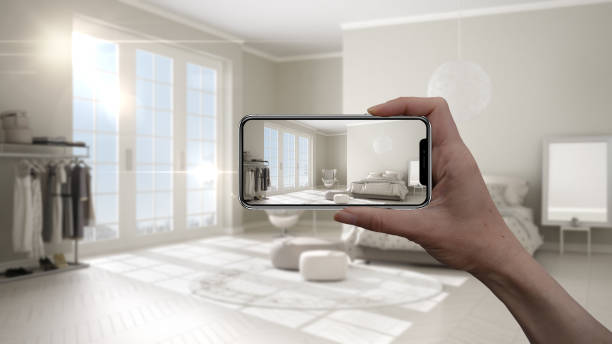 istock Hand holding smart phone, AR application, simulate furniture and interior design products in real home, architect designer concept, blur background, classic bedroom 1075428232