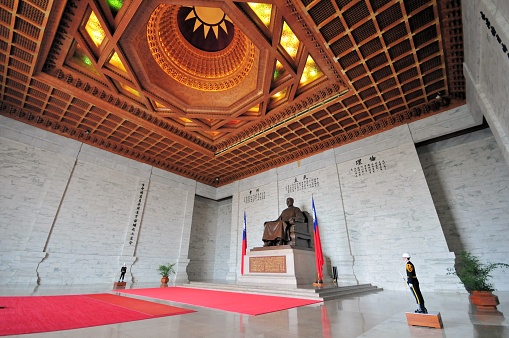 Taipei, Taiwan / Formosa / ROC:  Chiang Kai-shek's statue flanked by Republic of China flags and under the white sun of the Kuomintang - bronze ceiling decorated with gold - Chiang Kai-shek Memorial Hall - sculptor Xie Dongliang - wide angle