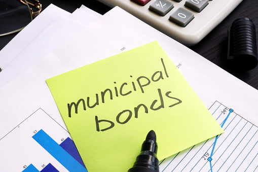 Municipal bond written on a memo stick and documents.