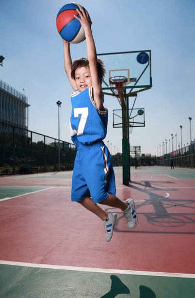 istock Cute little boy playing basketball 1075443788