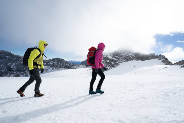 istock mountaineers climbers hikers in warm outdoors clothes walking on snow 1075448016